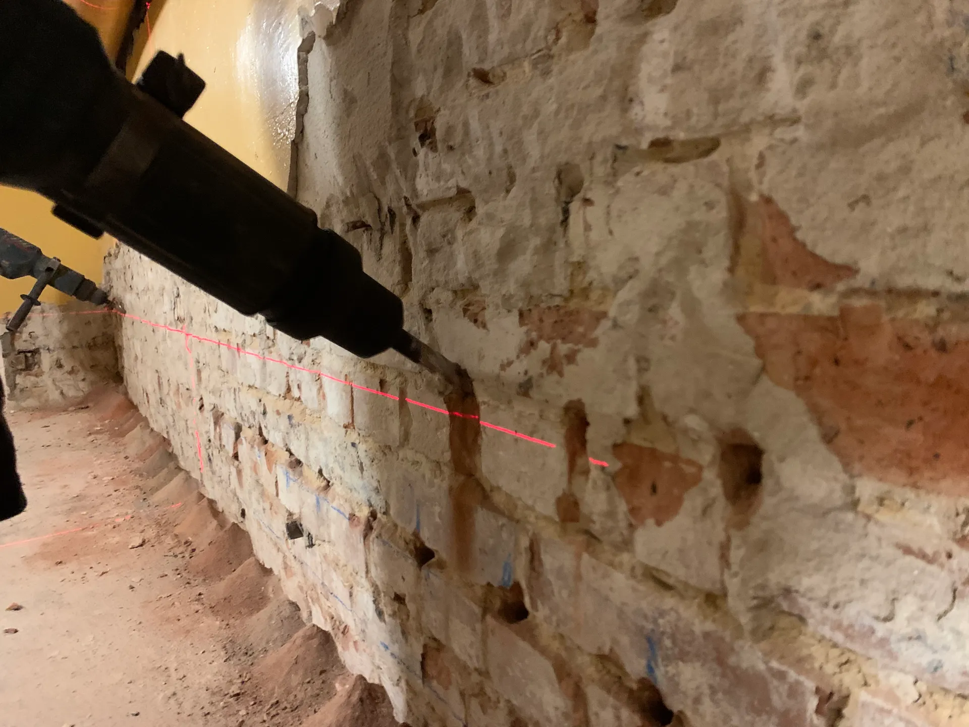 Pracownik wykonujący iniekcję krystaliczną w murze